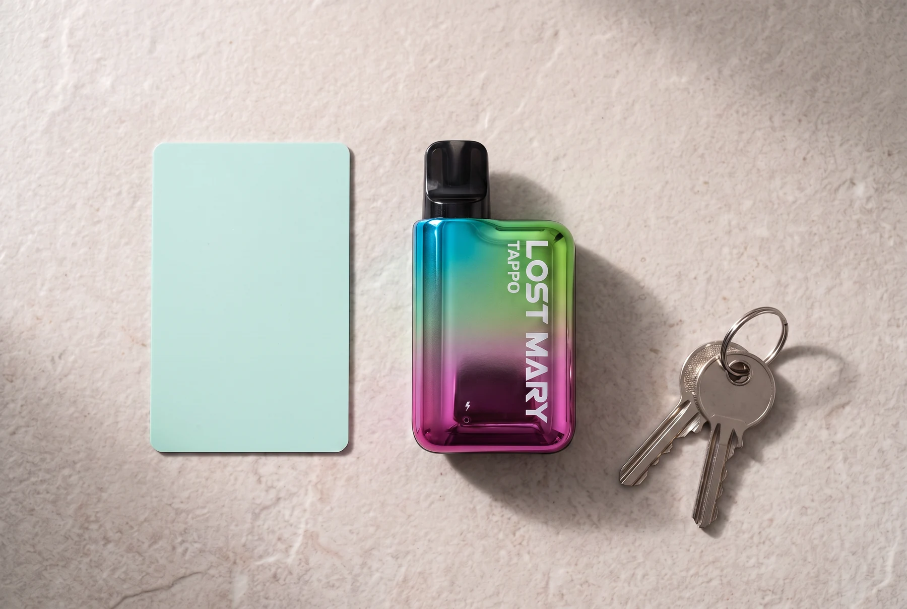 Lost Mary Tappo device arranged beside a blank bank-card-sized card and two house keys for pocket-scale context